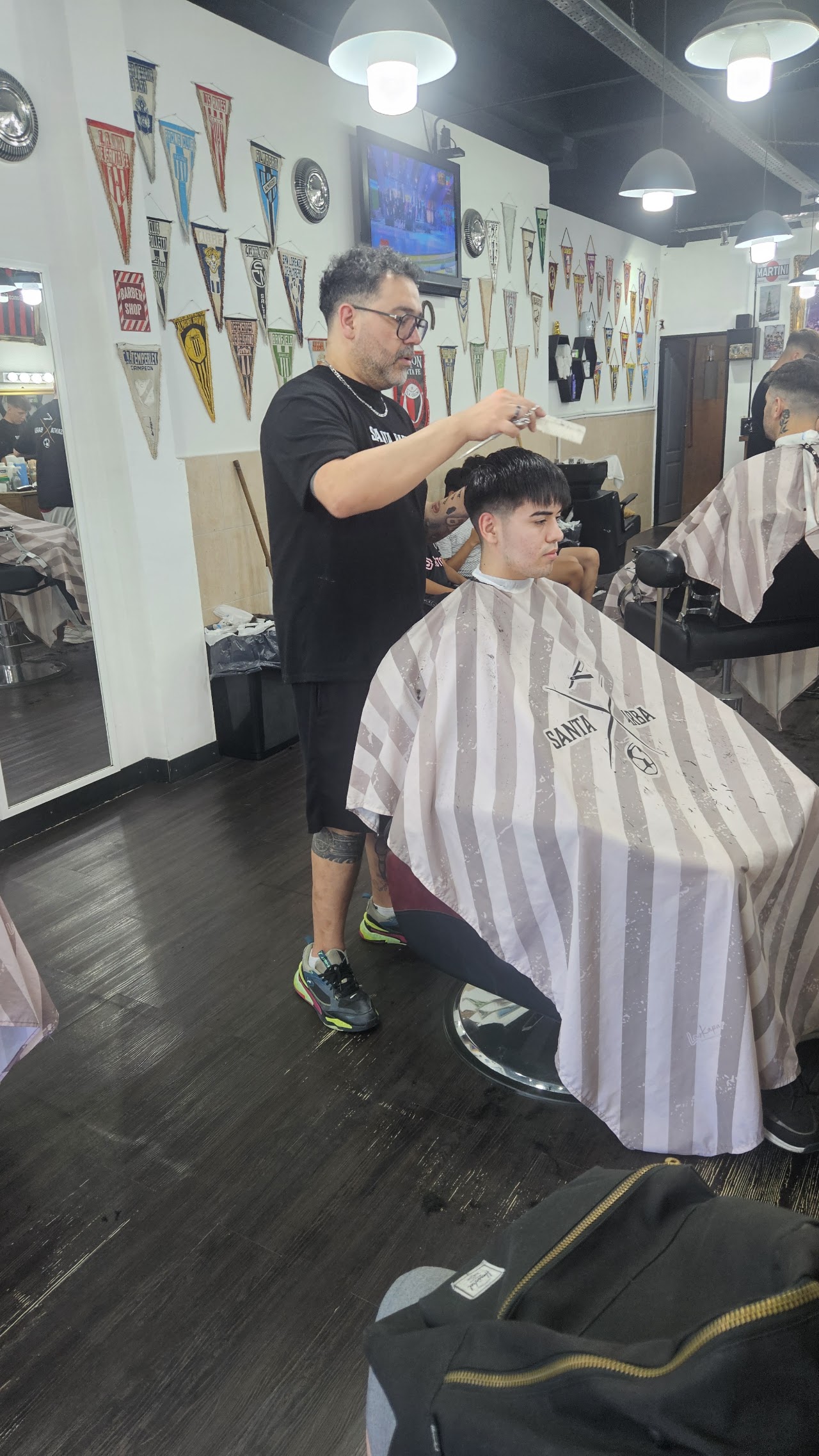 Barbero de Santa Barba cortando el pelo dentro del local